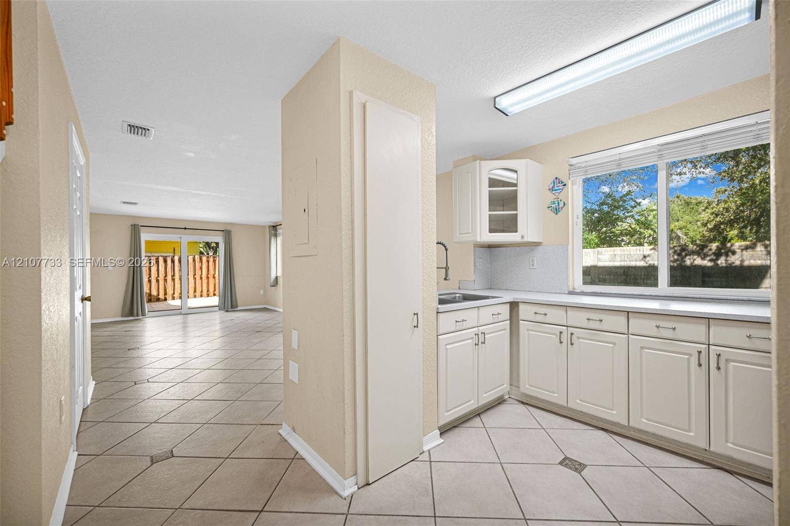 19606 SW 103rd Court, #4, Cutler Bay, FL 33157 Kitchen featuring white cabinetry, solid surface countertops, and tile flooring with decorative inserts