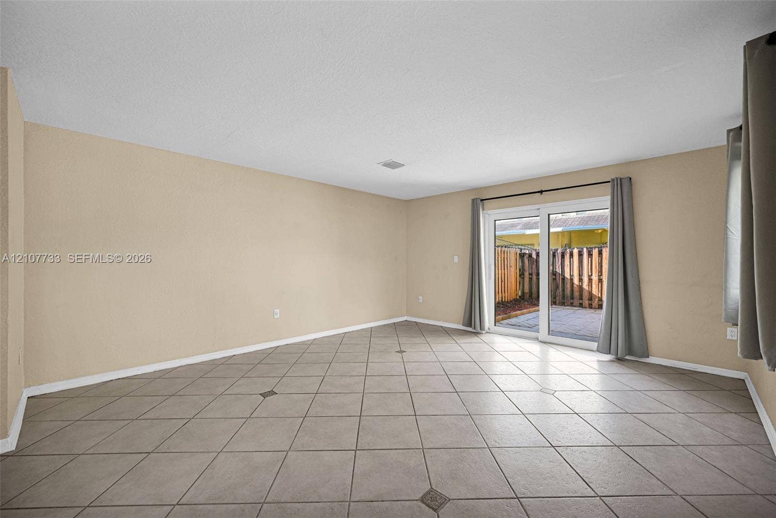 19606 SW 103rd Court, #4, Cutler Bay, FL 33157 Interior space featuring diagonal ceramic tile flooring and sliding glass doors leading to a paved outdoor area