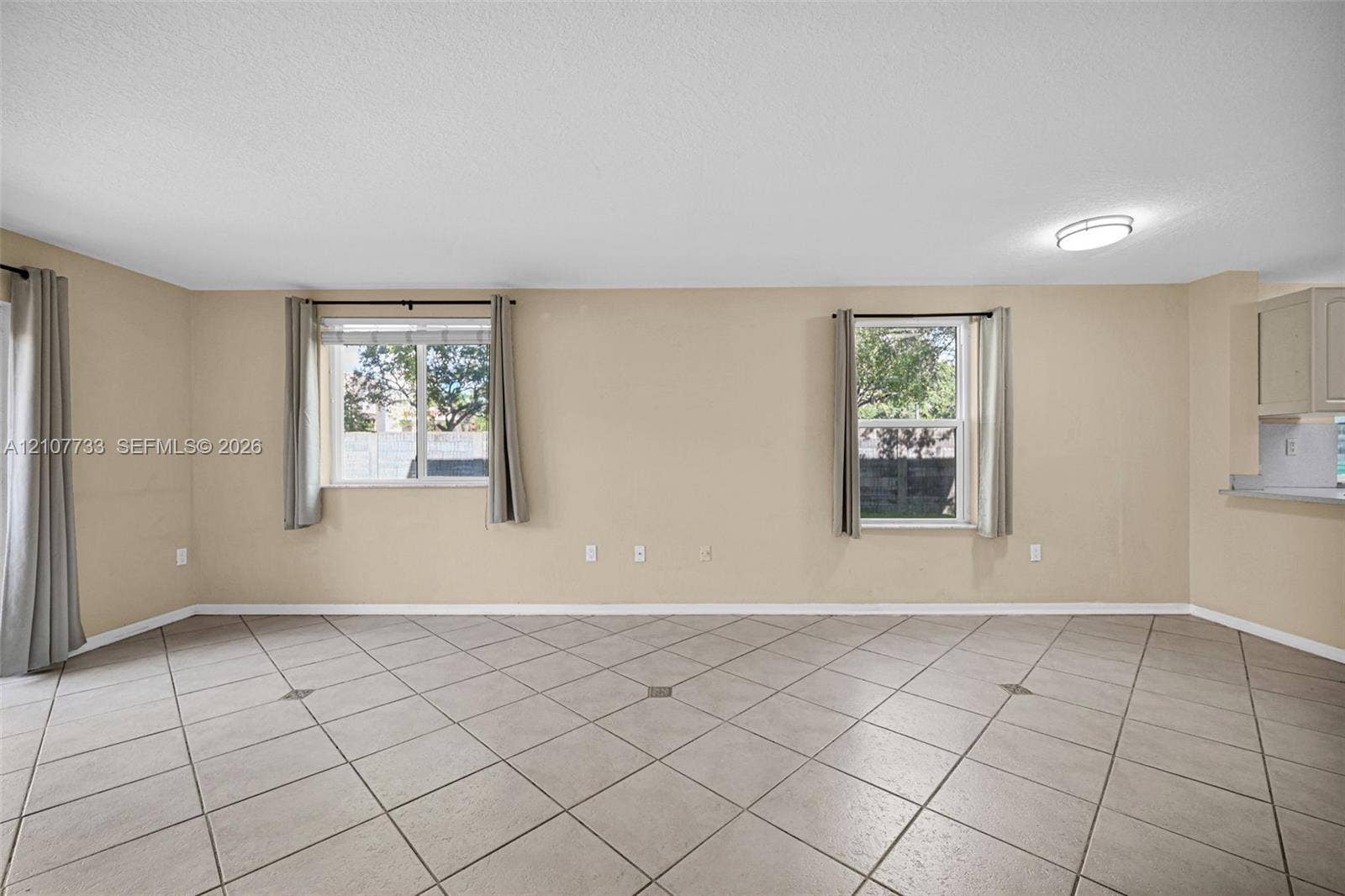 19606 SW 103rd Court, #4, Cutler Bay, FL 33157 Spacious room featuring neutral wall tones, large-format tile flooring, dual windows, and recessed ceiling lighting