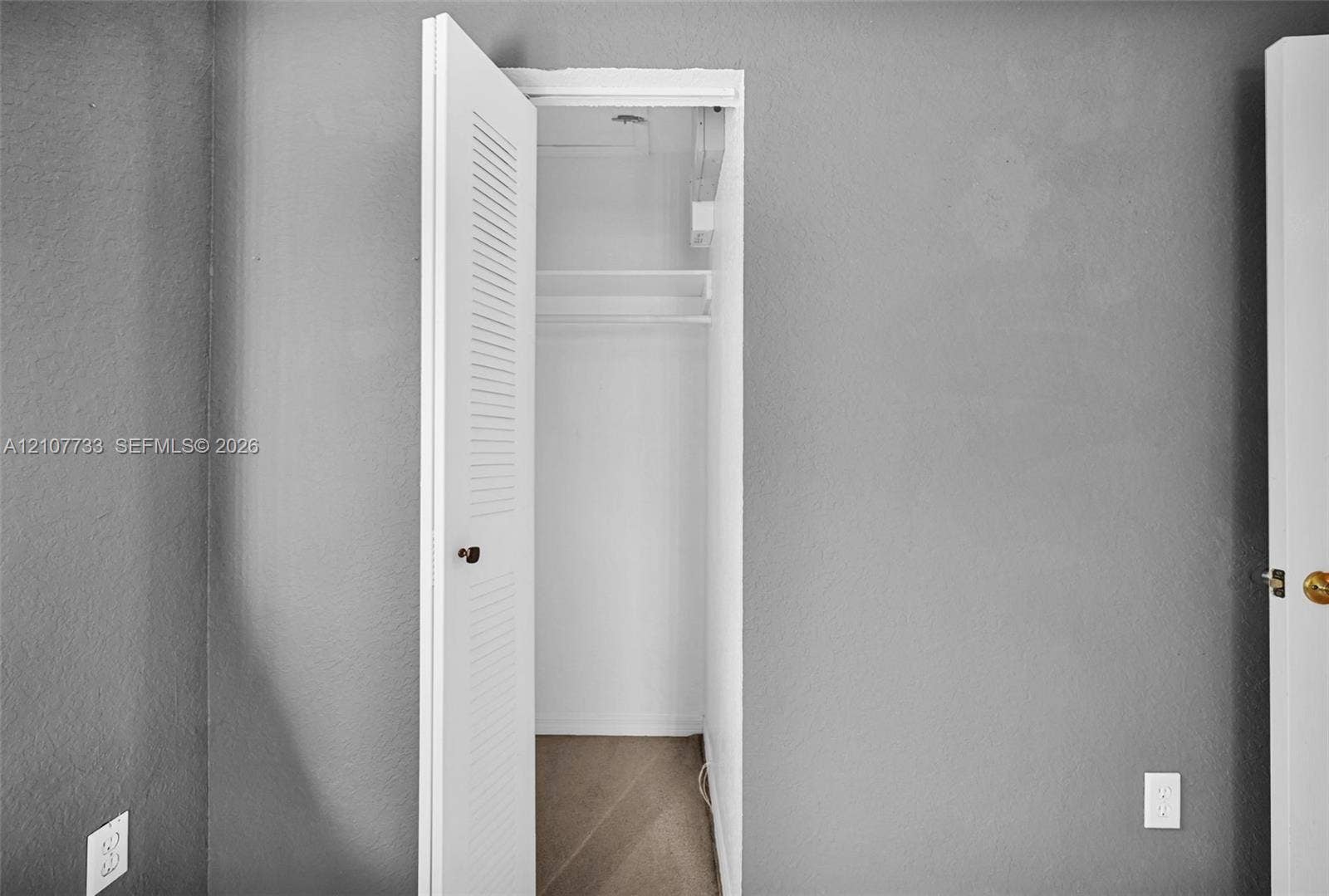 19606 SW 103rd Court, #4, Cutler Bay, FL 33157 Closet featuring a louvered door, built-in shelving, and carpeted flooring