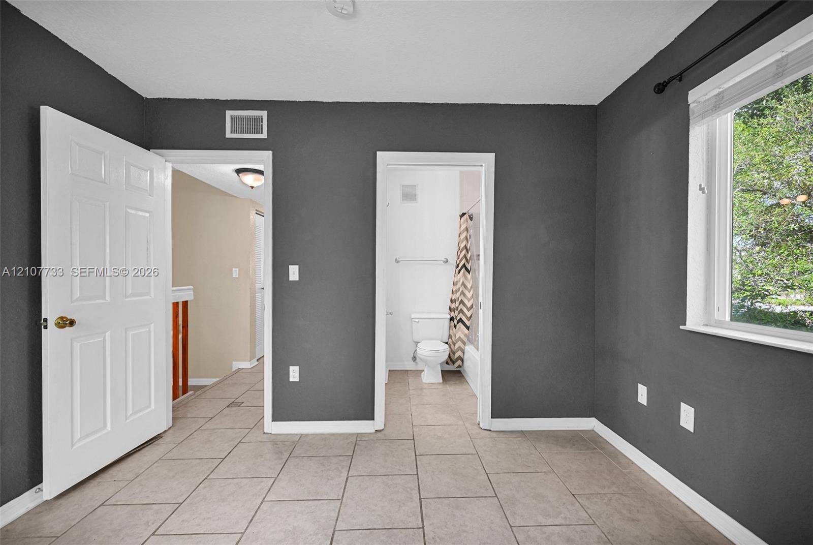 19606 SW 103rd Court, #4, Cutler Bay, FL 33157 Room featuring tile flooring, painted charcoal-toned walls, and a multi-pane window