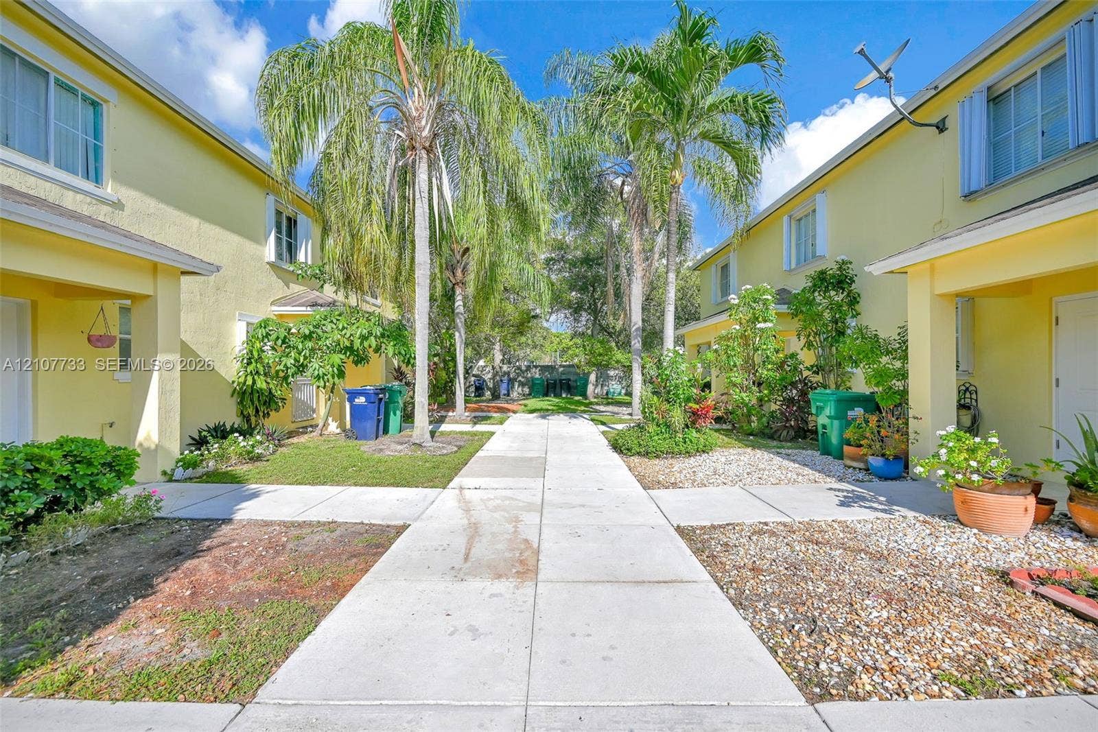 19606 SW 103rd Court, #4, Cutler Bay, FL 33157 Stucco exterior with multi-story facades, concrete walkway, and mature palm landscaping