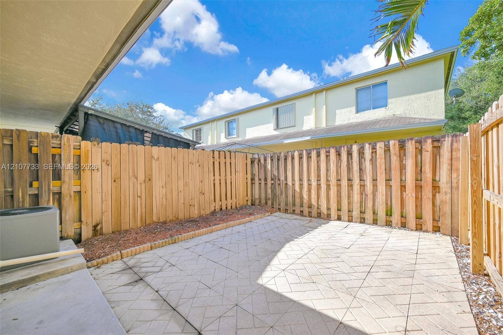 19606 SW 103rd Court, #4, Cutler Bay, FL 33157 Private patio area featuring stone-paver flooring, enclosed by full-height wood fencing
