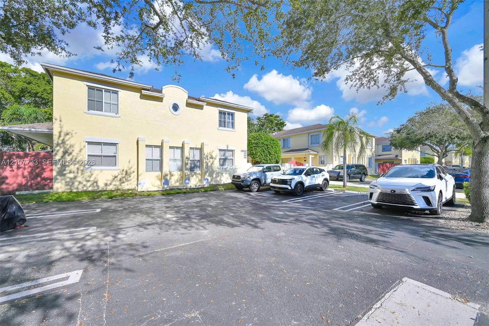 19606 SW 103rd Court, #4, Cutler Bay, FL 33157 Two-story stucco exterior featuring a circular accent window, multi-paned windows, pilasters, and dedicated asphalt parking area