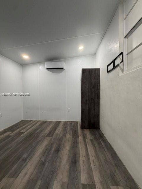 Interior space featuring wood-finish flooring, recessed lighting, a wall-mounted ductless climate control unit, and floor-to-ceiling built-in cabinetry