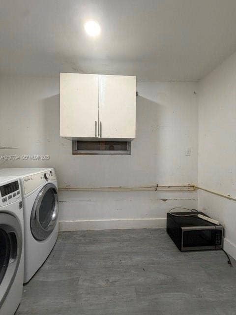 Wall-mounted white cabinetry and grey wood-finish flooring