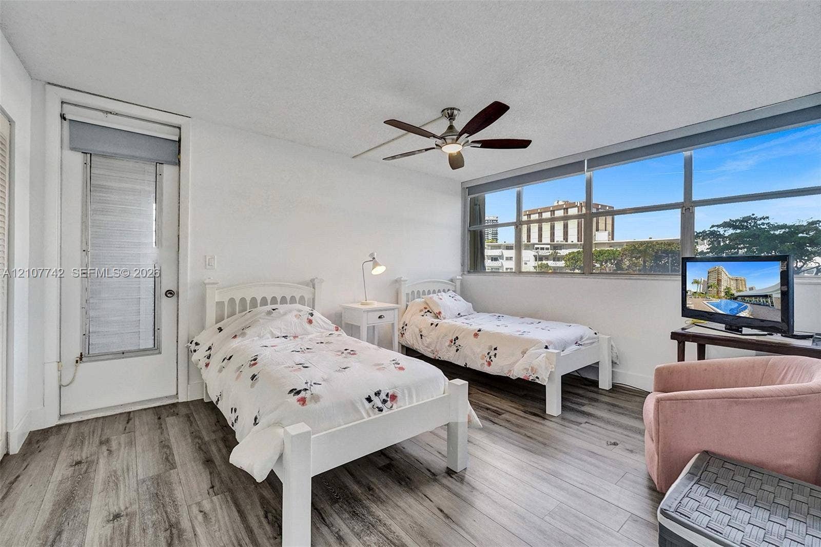 100 Golden Isles Drive, #112, Hallandale Beach, Hallandale Beach, FL 33009 Wood-finish flooring, floor-to-ceiling windows, and a ceiling fan with integrated lighting