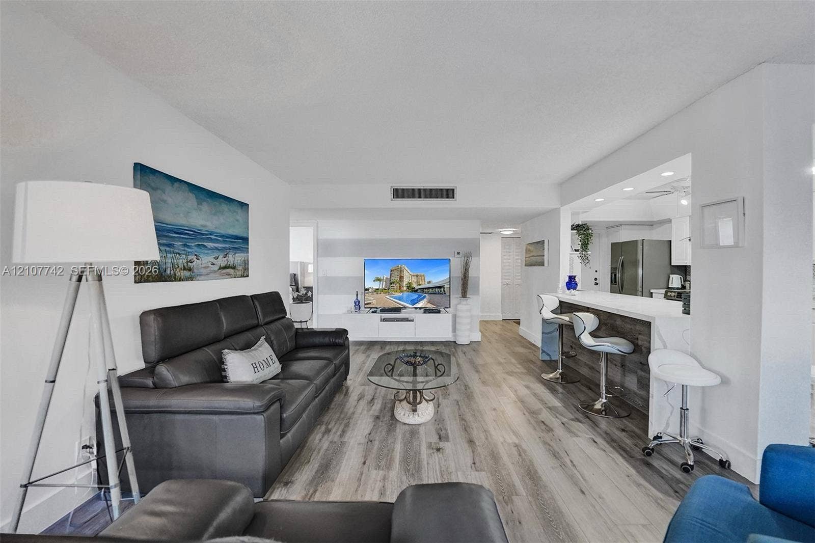 100 Golden Isles Drive, #112, Hallandale Beach, Hallandale Beach, FL 33009 Open-concept living space featuring wood-finish flooring, recessed lighting, and a breakfast bar with a stone-finish facade