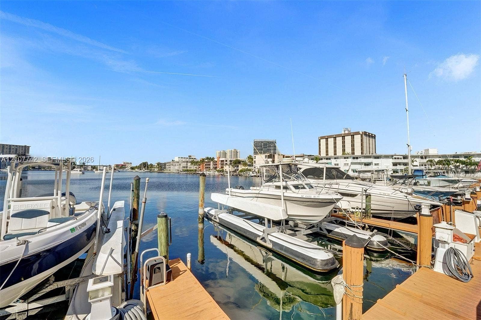 100 Golden Isles Drive, #112, Hallandale Beach, Hallandale Beach, FL 33009 Private deep-water boat slips featuring wooden decking, vertical pilings, and mechanical boat lifts