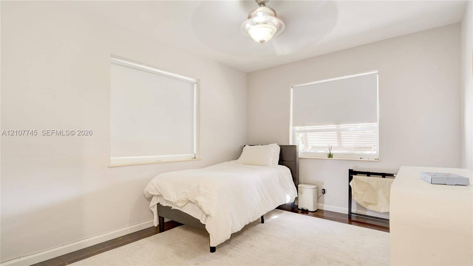 Neutral wall finishes, wood-finish flooring, recessed windows, and a central ceiling-mounted light fixture