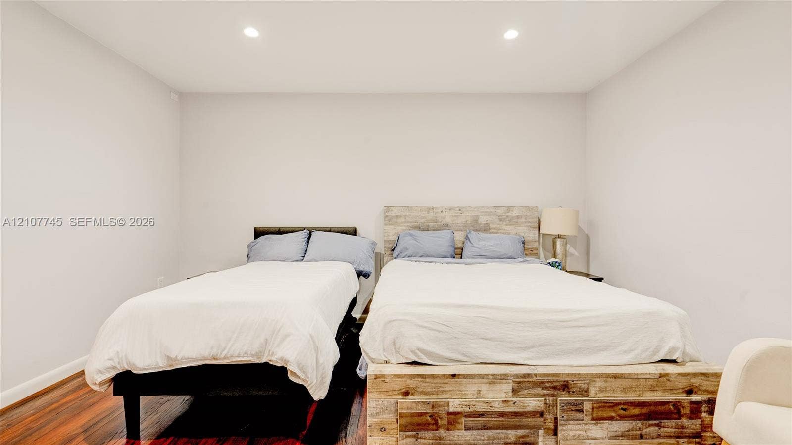 Room featuring neutral-toned walls, wood-finish flooring, and recessed ceiling lighting
