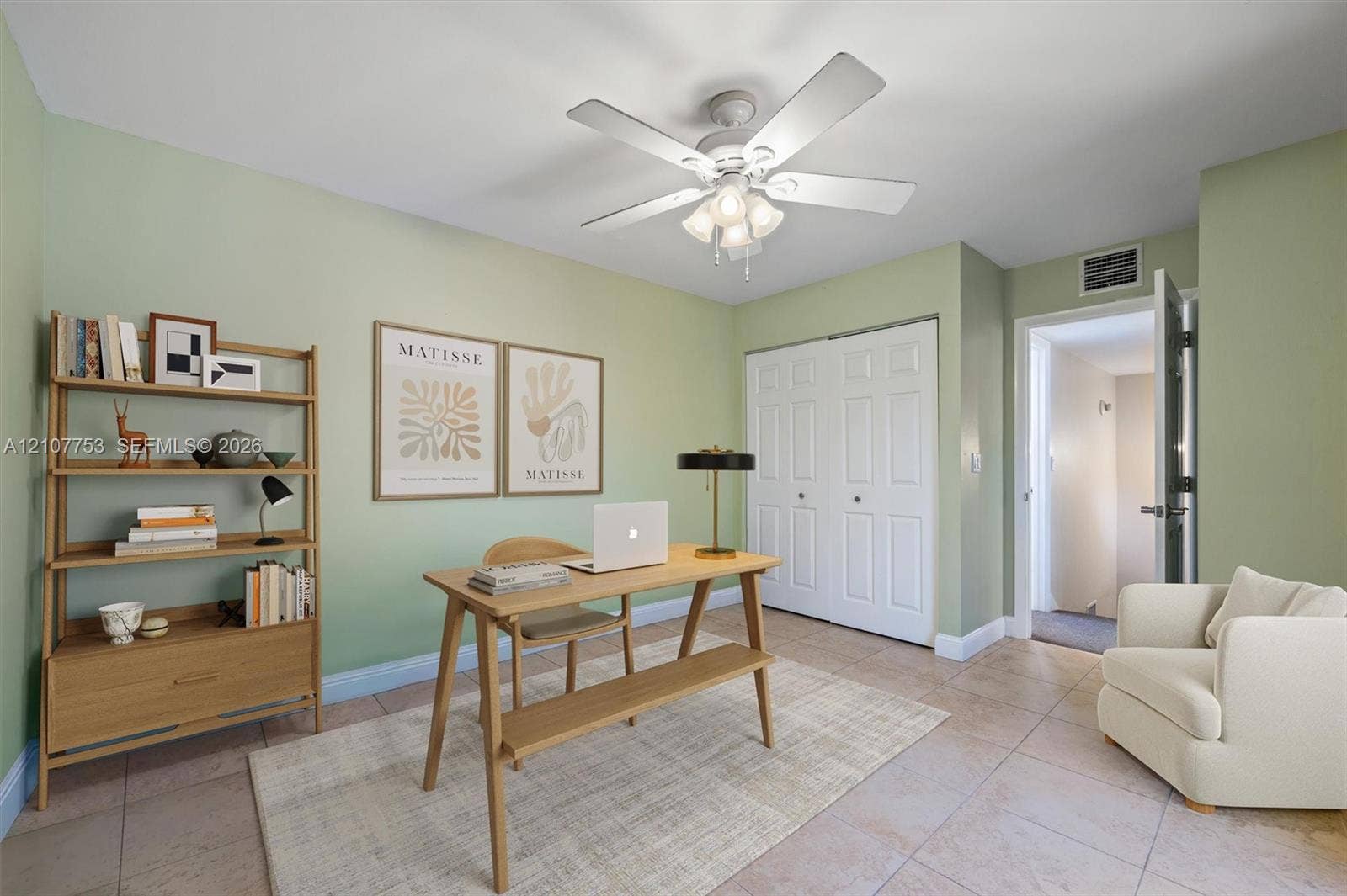 Room featuring tile flooring, a central ceiling fan with integrated lighting, and a double-door closet