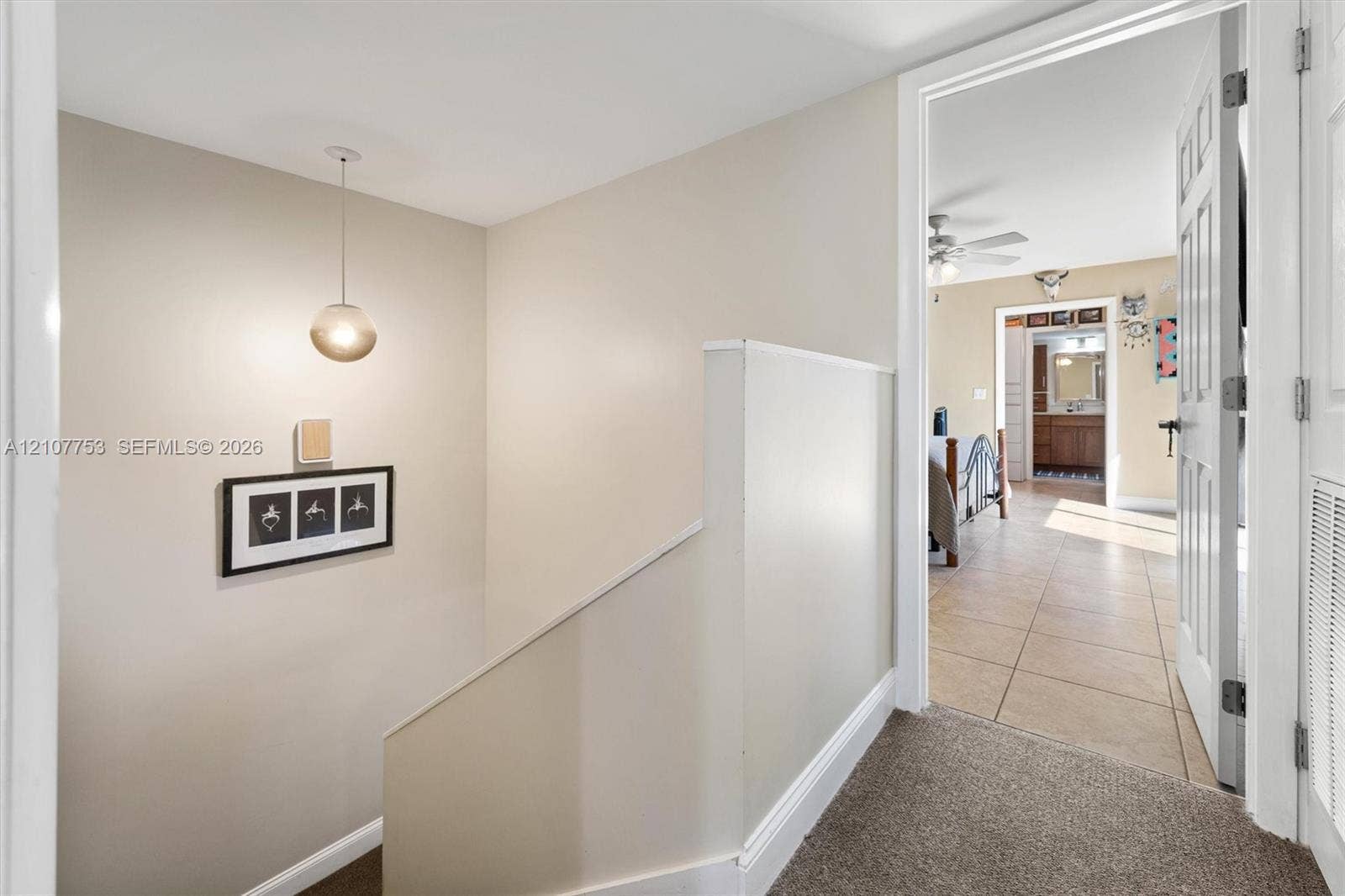 Stairwell featuring neutral wall paint, carpeted flooring, and a suspended globe pendant light