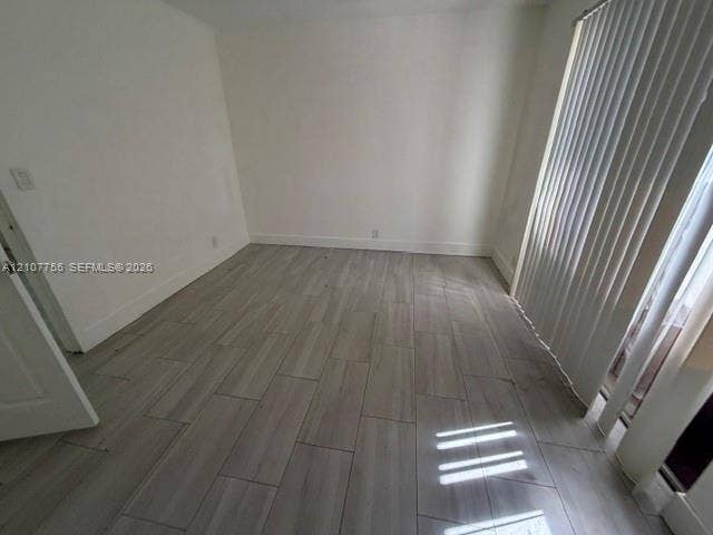 930 SW 29th Street, #A-C, Fort Lauderdale, Fort Lauderdale, FL 33315 Neutral-toned interior room featuring wood-finish tile flooring and vertical window blinds