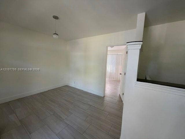 930 SW 29th Street, #A-C, Fort Lauderdale, Fort Lauderdale, FL 33315 Interior space featuring wood-finish flooring, a neutral color palette, a single-bulb pendant light fixture, and a half-wall with a cap molding detail