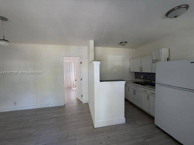 930 SW 29th Street, #A-C, Fort Lauderdale, Fort Lauderdale, FL 33315 Kitchen featuring white shaker-style cabinetry, a decorative mosaic tile backsplash, solid-surface countertops, and wood-finish tile flooring throughout