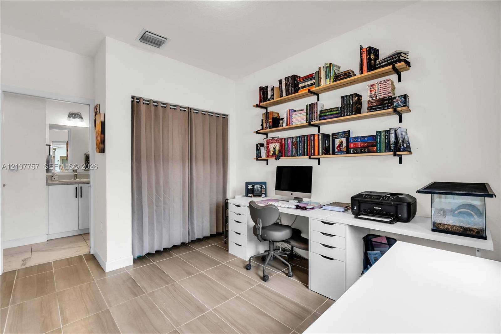 412 NW 12th Avenue, Florida City, FL 33034 Room featuring large-format ceramic tile flooring, built-in wall-mounted shelving, and a double-door closet