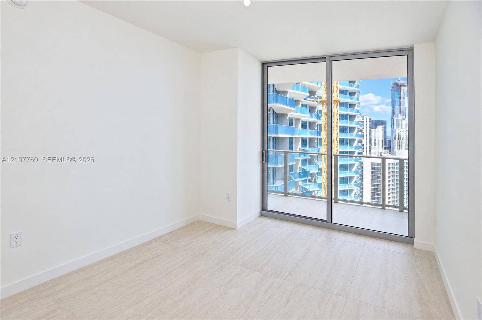 Interior space featuring wood-finish flooring, floor-to-ceiling sliding glass doors, and a private balcony