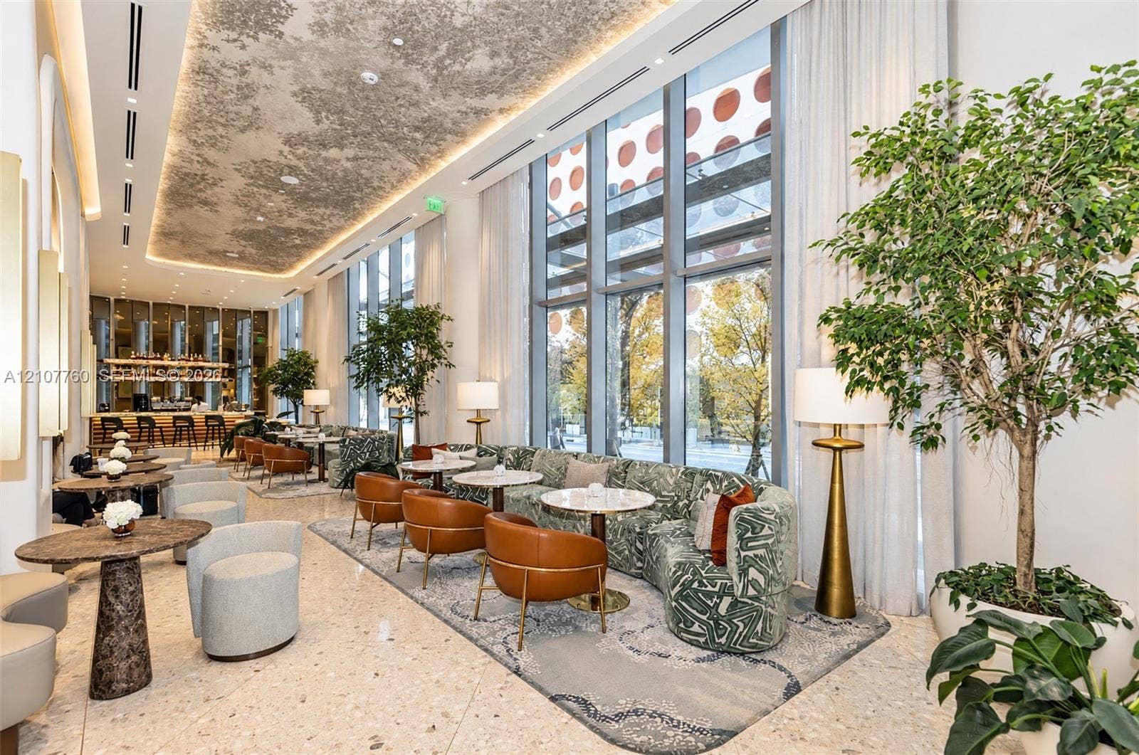 Double-height floor-to-ceiling windows, polished stone flooring, intricate decorative ceiling plasterwork, and recessed cove lighting