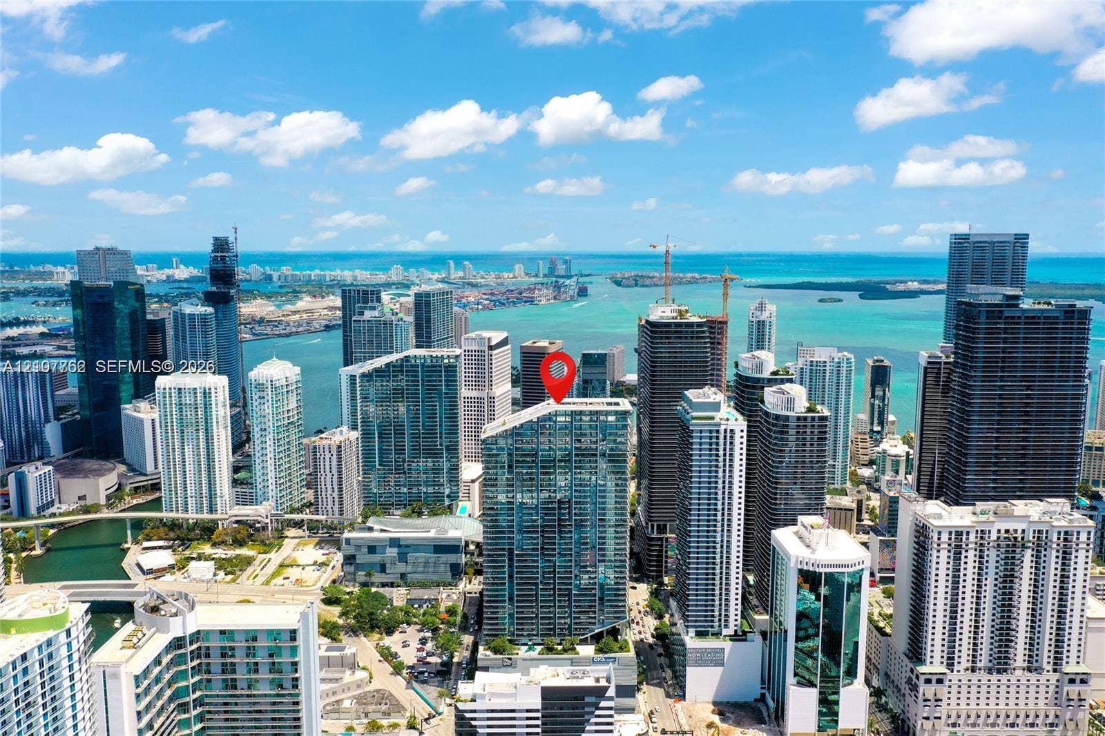 Aerial perspective of a high-rise tower featuring a glass-facade exterior and a prominent downtown urban skyline orientation