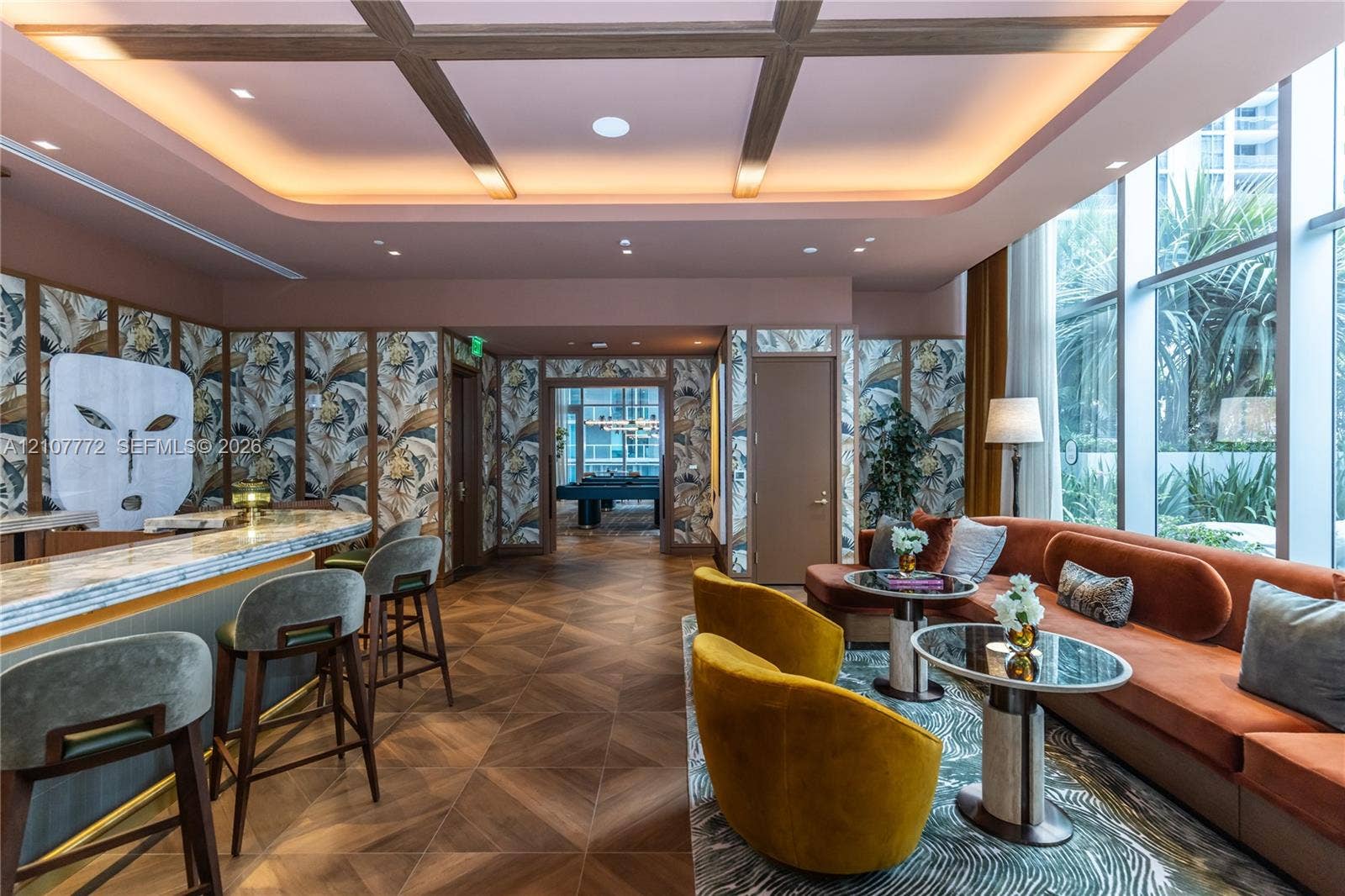 77 SE 5th Street, #1210, Miami, Miami, FL 33131 Coffered ceiling with integrated cove lighting, wood-finish flooring in a chevron pattern, floor-to-ceiling windows, built-in bar, and custom wall treatments