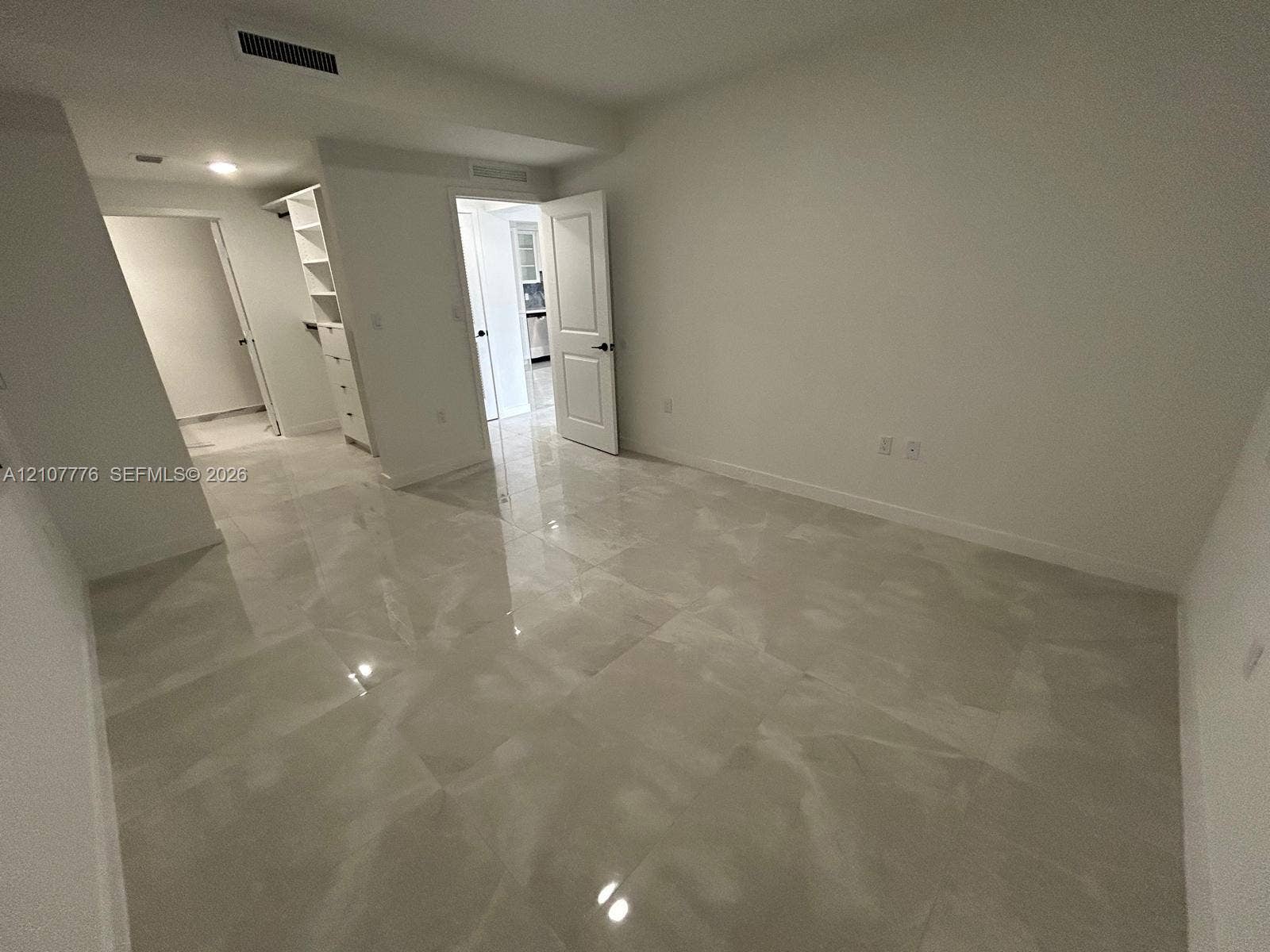 Interior room featuring large-format tile flooring, built-in shelving, and recessed ceiling lighting