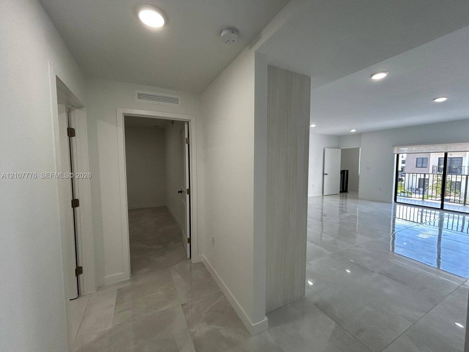 Large-format polished tile flooring, recessed ceiling lighting, and a neutral color palette