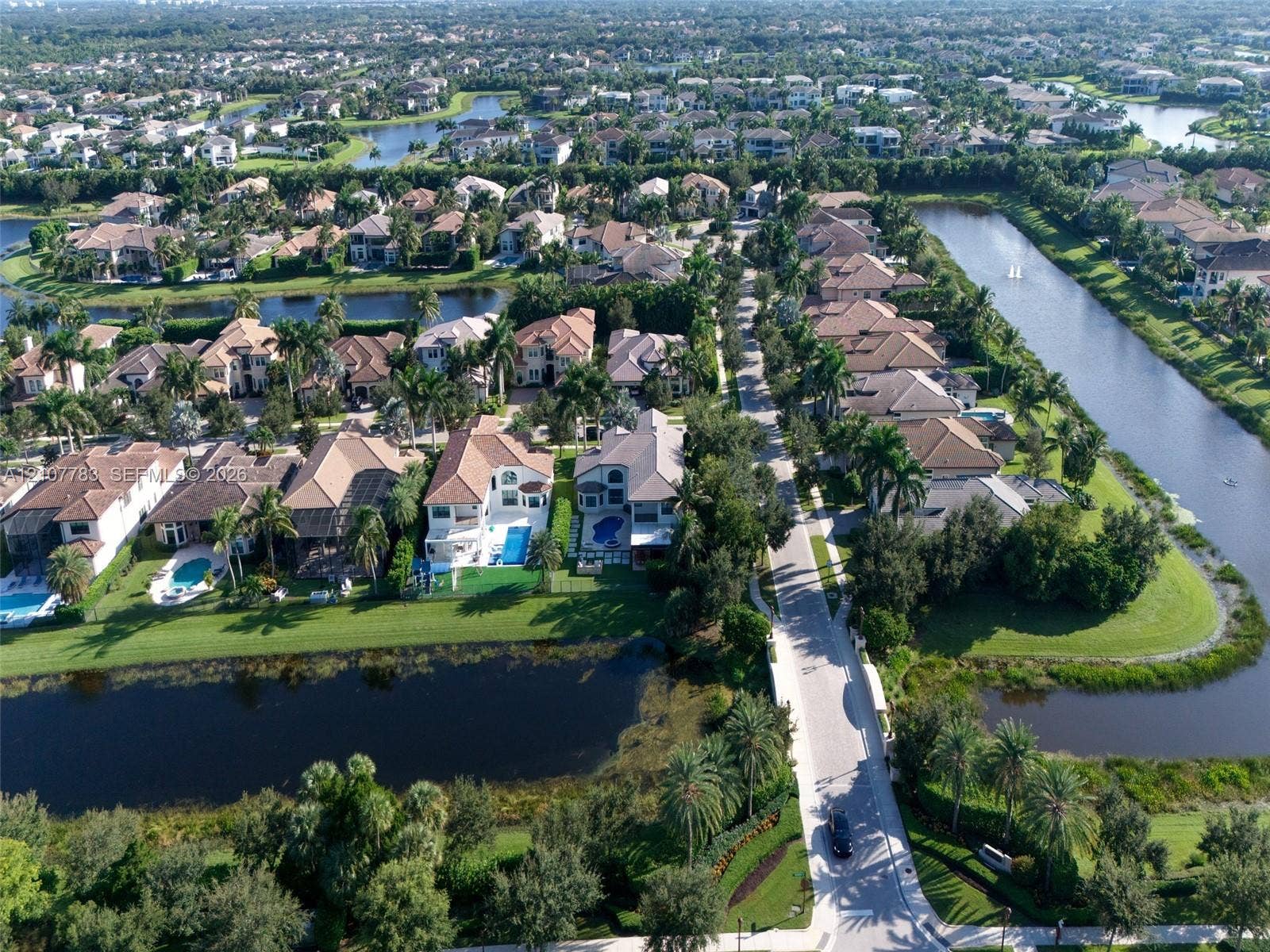 9328 Tropez Lane, Delray Beach, FL 33446 Aerial perspective of a residential neighborhood featuring waterfront lots, multi-story dwellings, tile roofing, and integrated canal systems