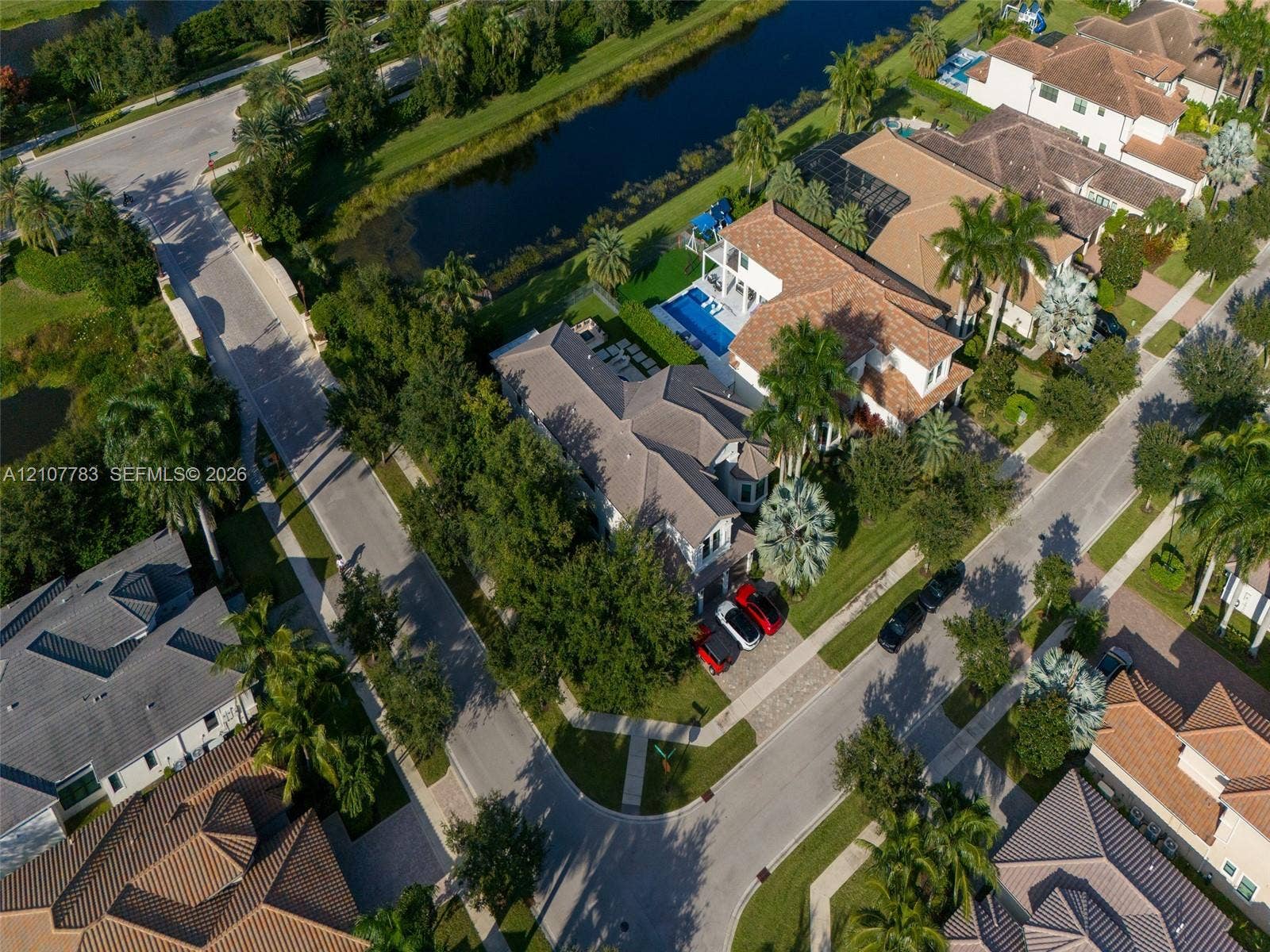 9328 Tropez Lane, Delray Beach, FL 33446 Aerial perspective featuring a multi-story residence with a tiled roof, an in-ground swimming pool, and a waterfront position