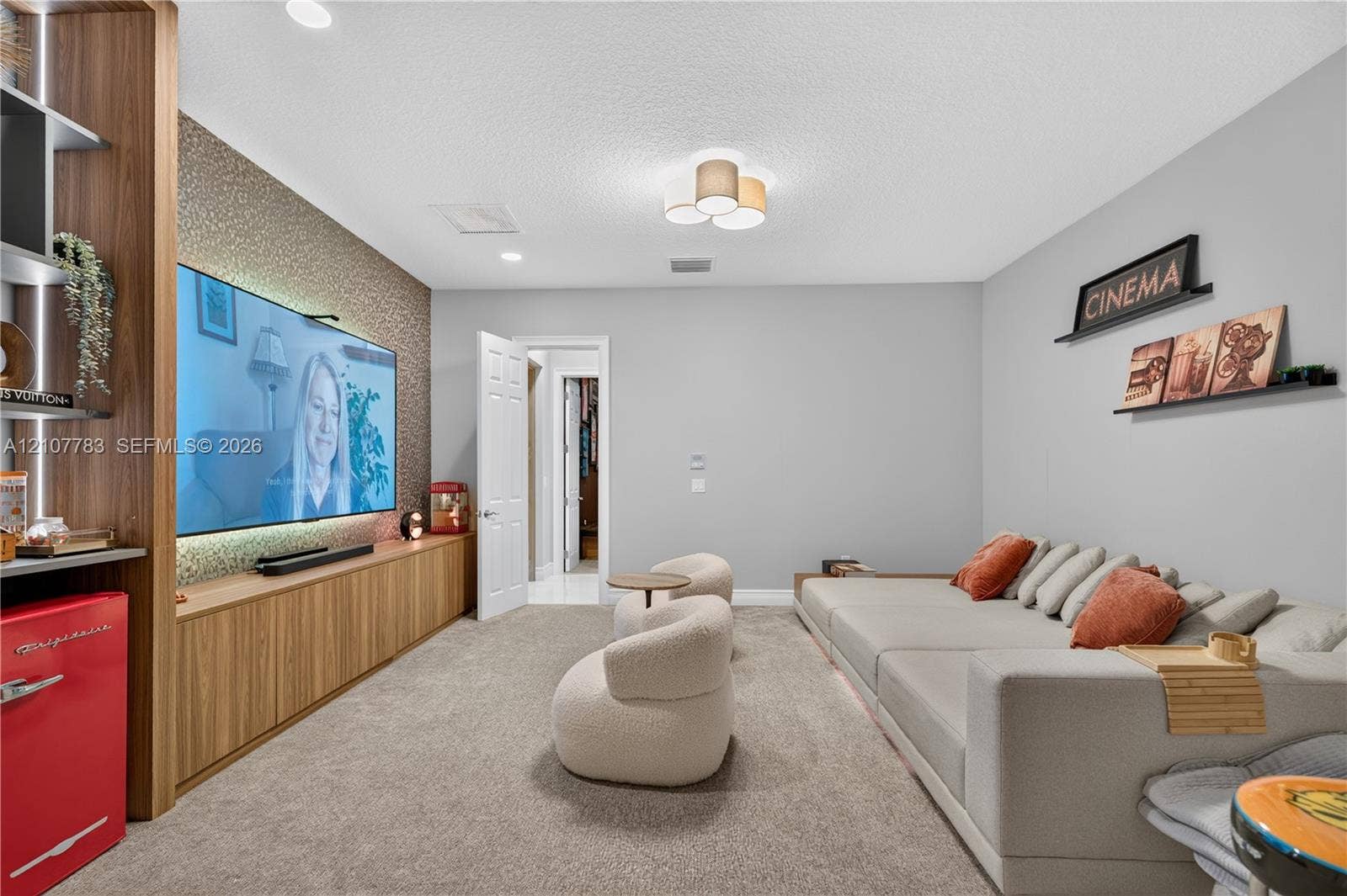 9328 Tropez Lane, Delray Beach, FL 33446 Custom built-in wood-finish cabinetry, textured accent wall, integrated recessed lighting, and flush-mount multi-bulb fixture