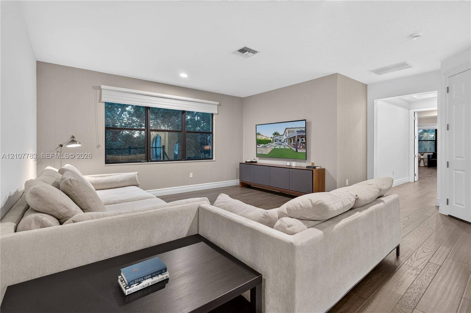 9328 Tropez Lane, Delray Beach, FL 33446 Neutral-toned interior featuring wood-finish flooring, multi-pane windows, recessed lighting, and a wall-mounted swing-arm lamp