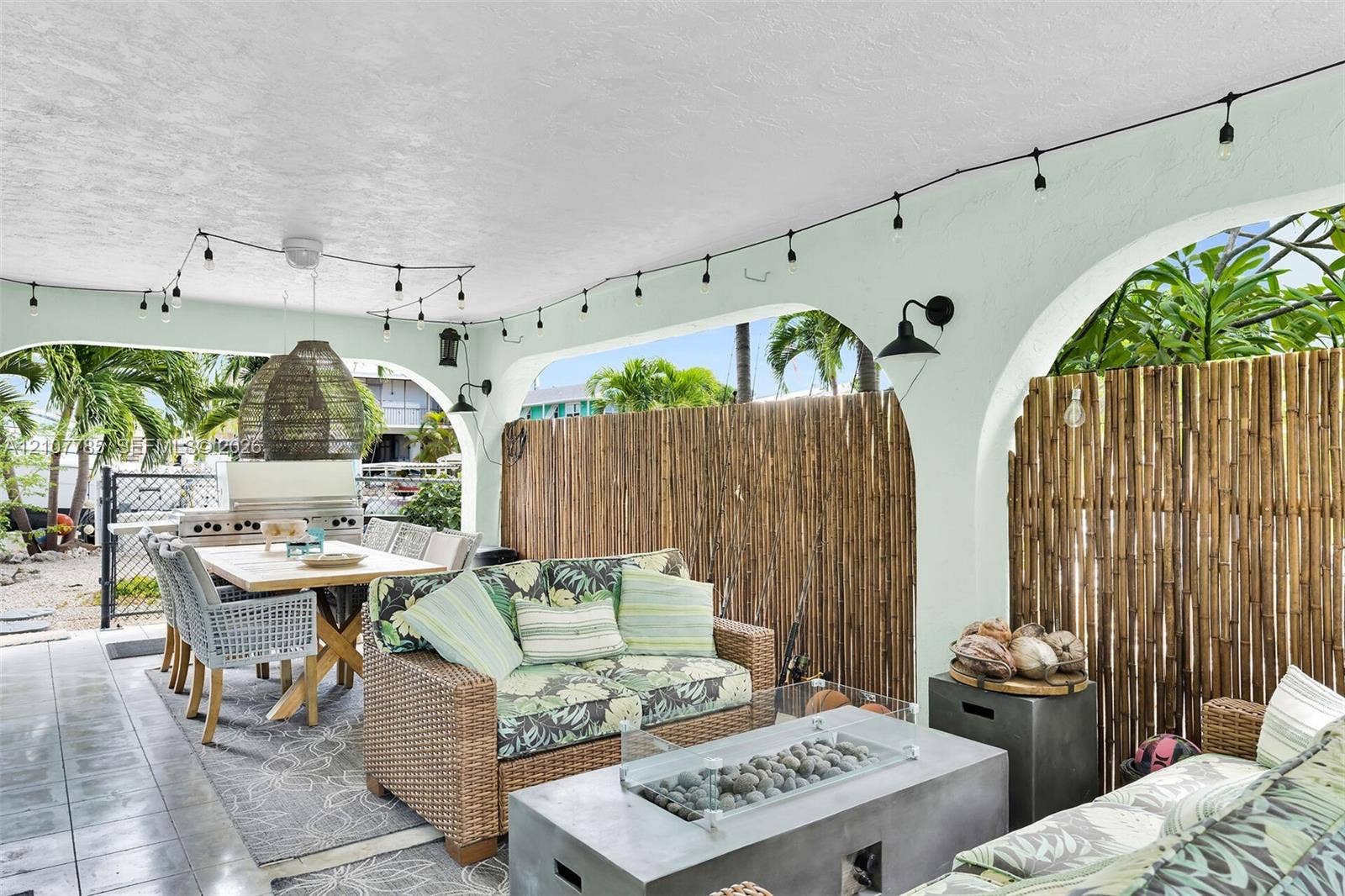 Covered patio featuring arched architectural details, smooth ceiling finish, and built-in stainless steel exterior grill