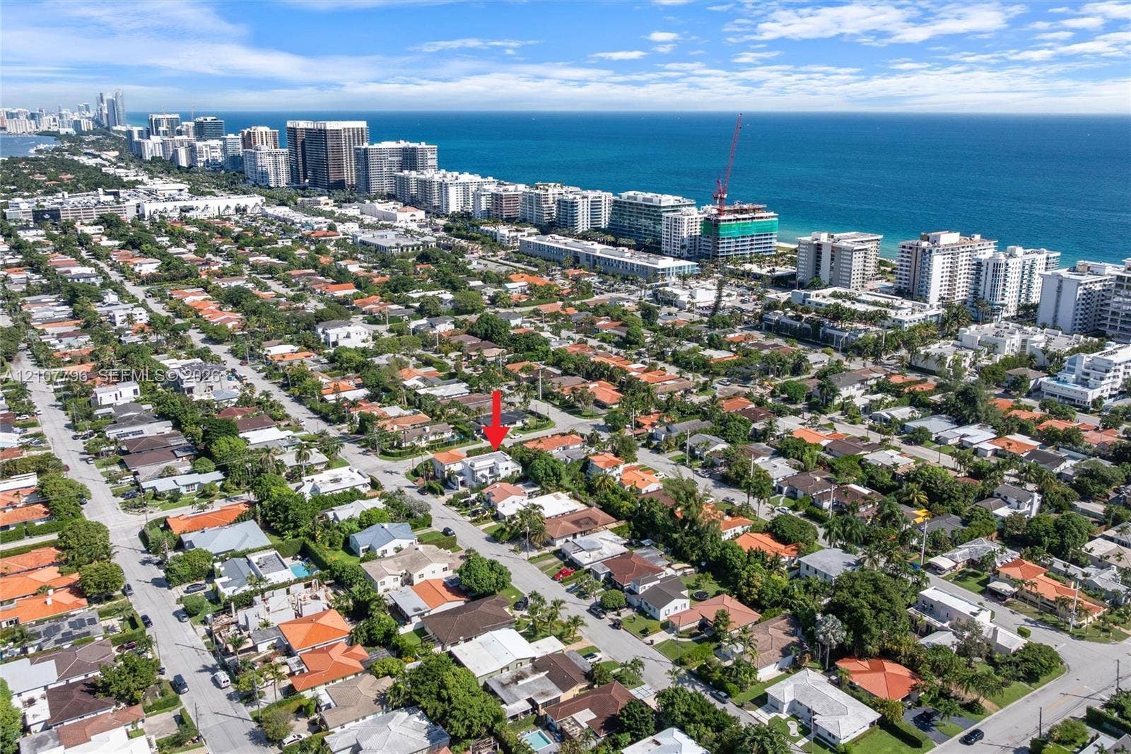 Aerial perspective of a residential property situated in a coastal area, featuring mature landscaping and proximity to the Atlantic Ocean