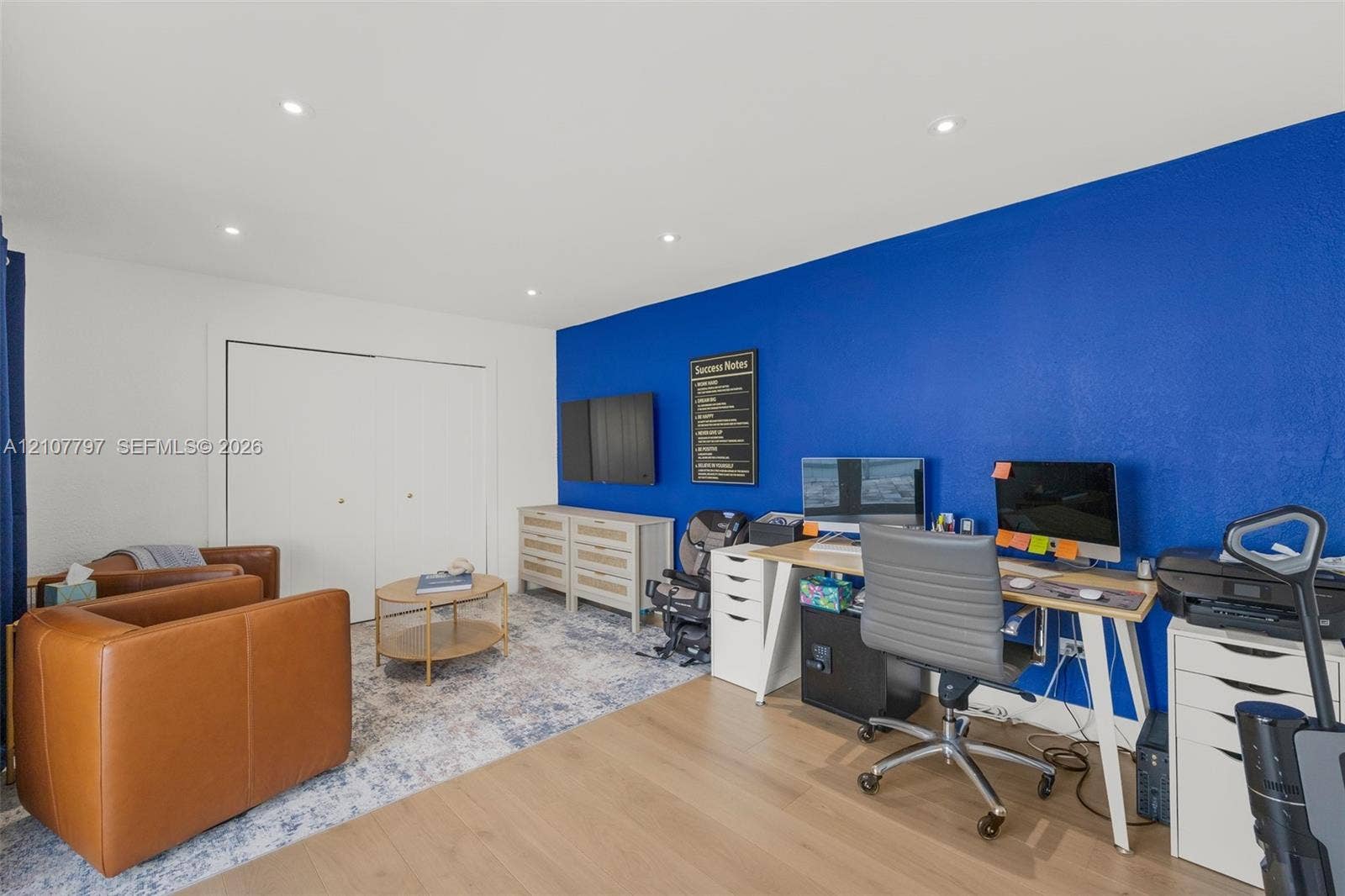 Room featuring recessed lighting, wood-finish flooring, and a floor-to-ceiling closet with dual sliding doors