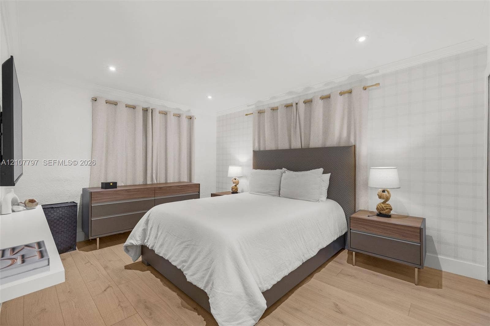 Wood-finish flooring, recessed lighting, and a textured grid-patterned accent wall