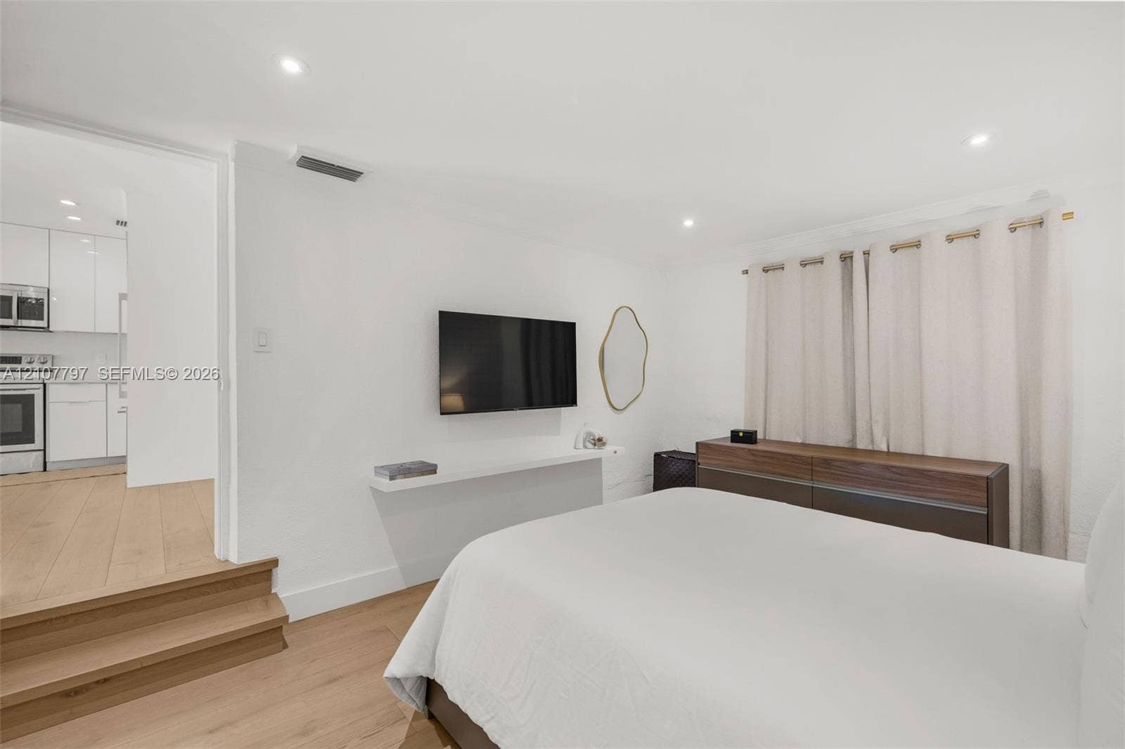 Room featuring light wood-finish flooring, recessed lighting, and a wall-mounted floating shelf