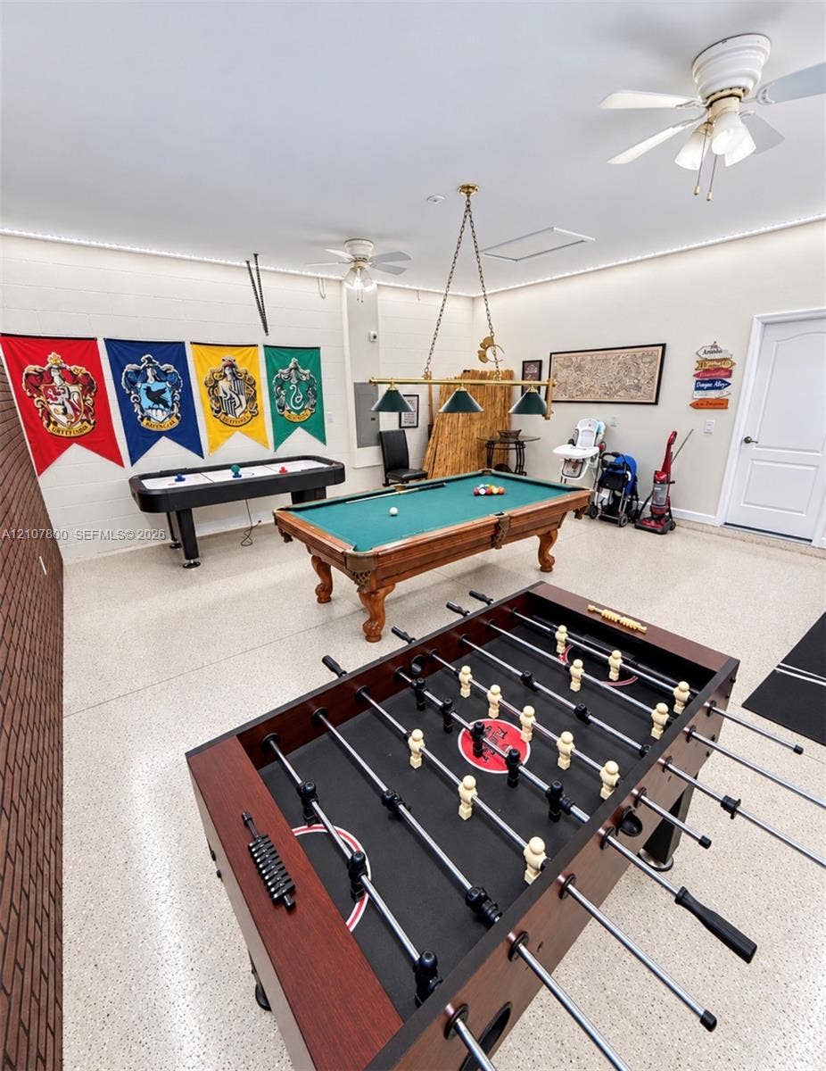 1476 Moon Valley, Davenport, FL 33896 Expansive multi-use room featuring an exposed brick wall, speckled epoxy flooring, recessed LED perimeter lighting, and dual ceiling fans