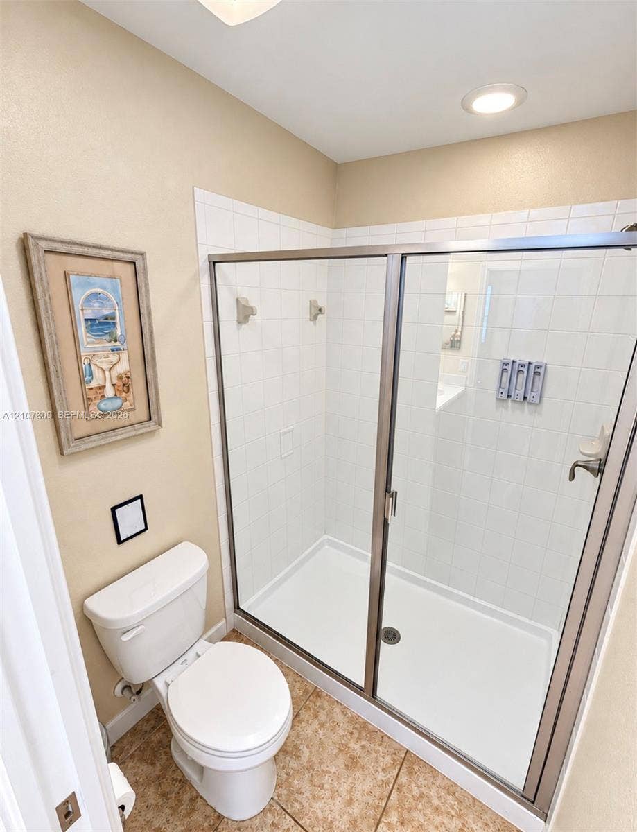 1476 Moon Valley, Davenport, FL 33896 Walk-in shower featuring a white tile surround, glass enclosure, metal framing, and recessed ceiling lighting