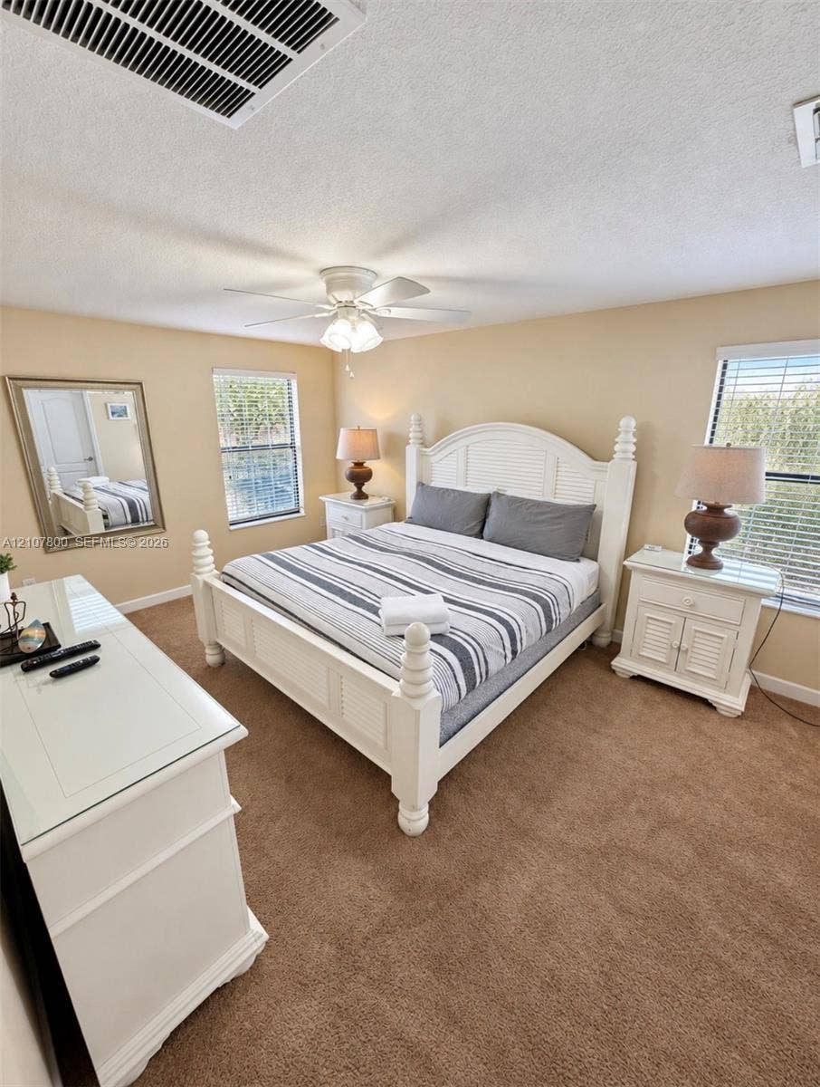1476 Moon Valley, Davenport, FL 33896 Carpeted room featuring multi-pane windows with horizontal blinds and an integrated ceiling fan with light fixture
