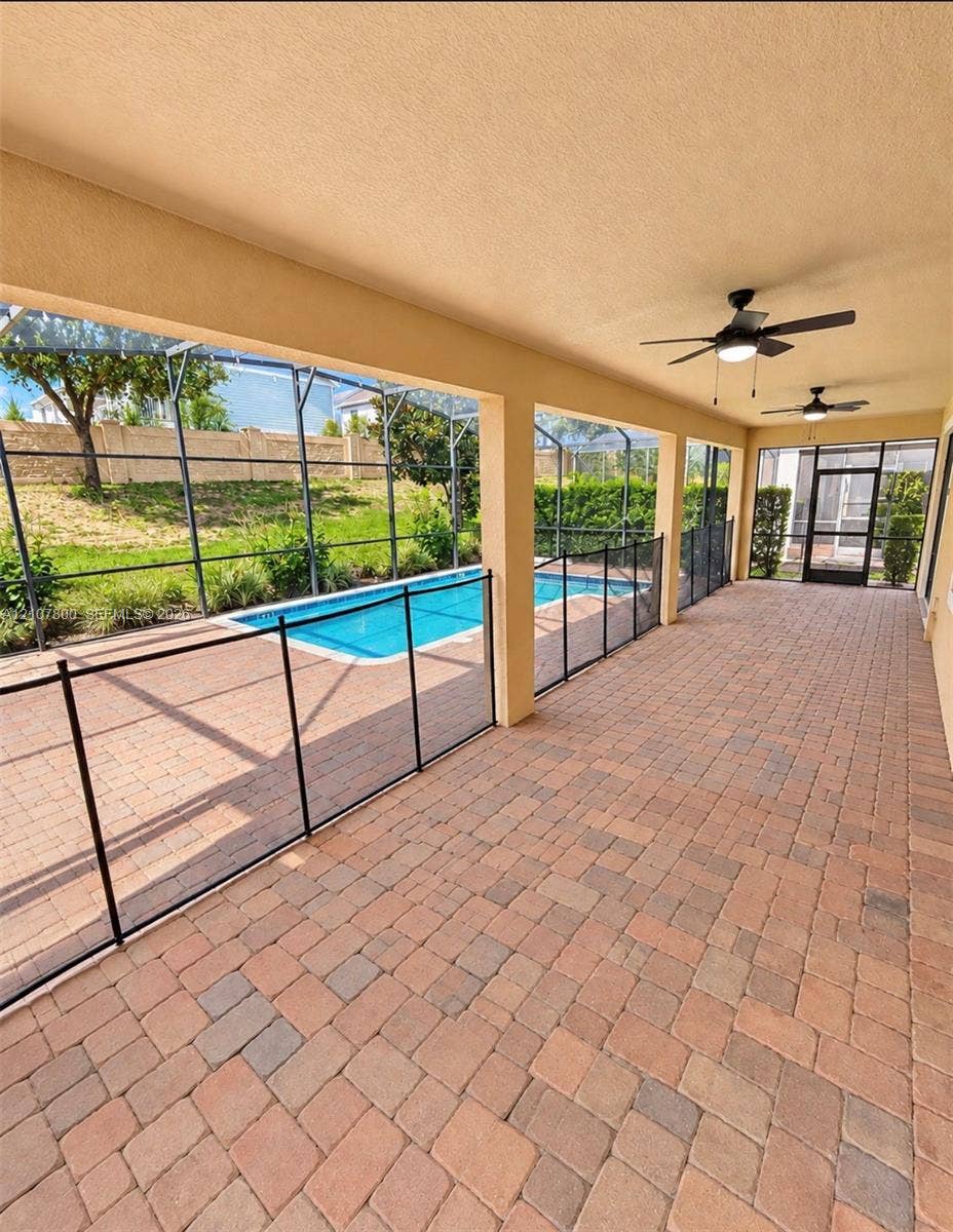 1476 Moon Valley, Davenport, FL 33896 Covered lanai featuring brick paver flooring, recessed ceiling fans, and an enclosed screen structure surrounding an in-ground swimming pool