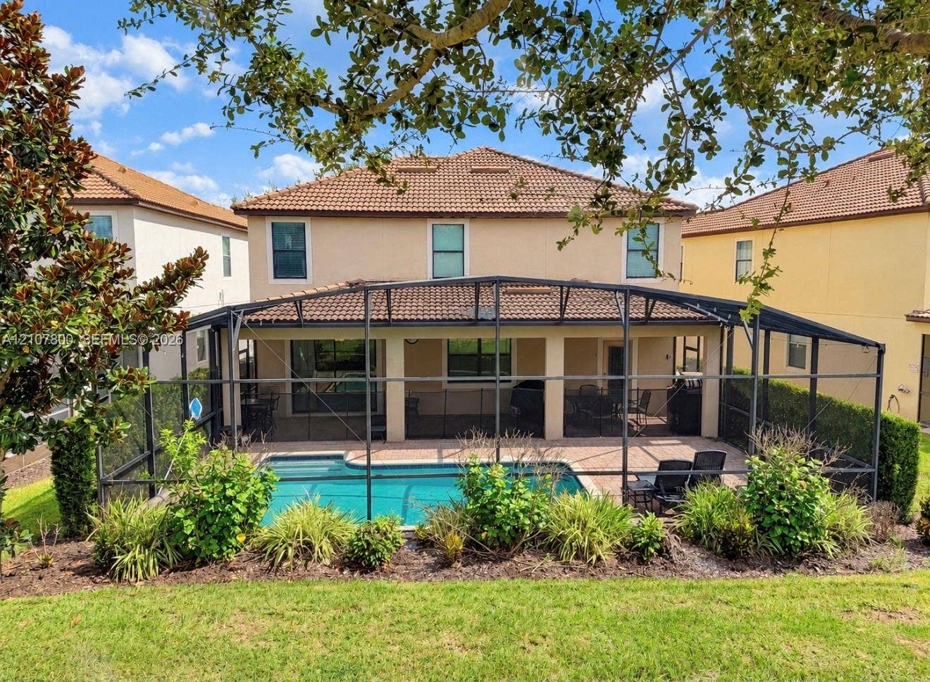 1476 Moon Valley, Davenport, FL 33896 Screen-enclosed patio with a paved deck, private swimming pool, stucco exterior, and multi-pitched tile roof