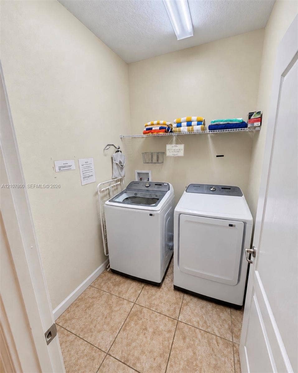 1476 Moon Valley, Davenport, FL 33896 Laundry area featuring tile flooring, wire shelving, and overhead linear lighting