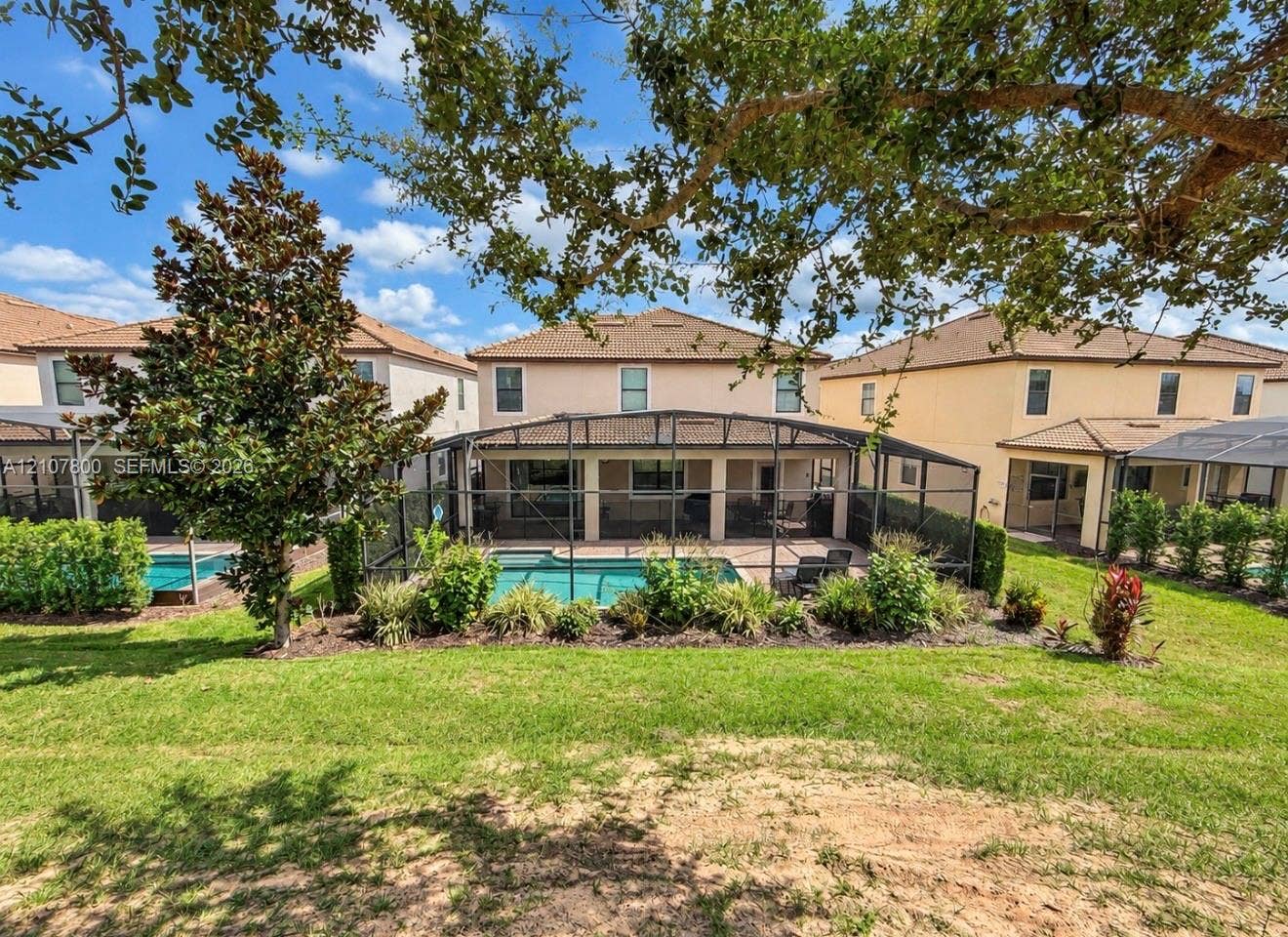 1476 Moon Valley, Davenport, FL 33896 Stucco exterior residence featuring a screened-in lanai, private swimming pool, brick paver patio, and landscaped perimeter