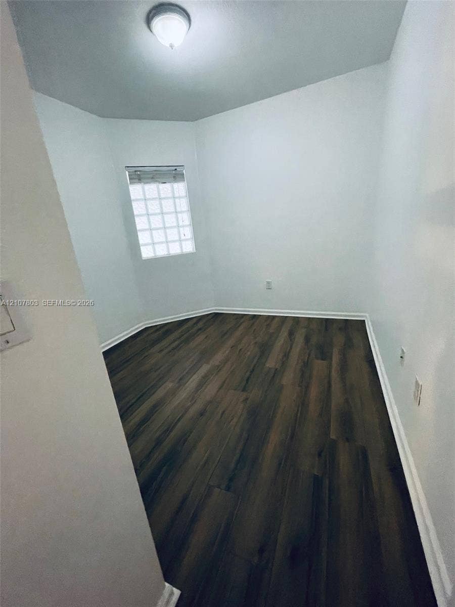 8620 NW 97th Avenue, #205, Doral, FL 33178 Multi-faceted room featuring wood-finish flooring, a glass block window, and a central ceiling-mounted light fixture