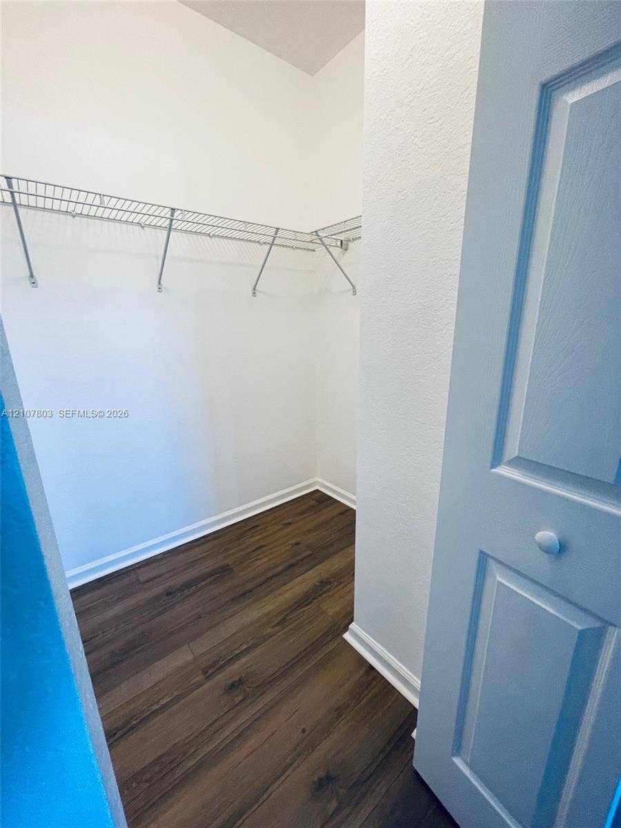 8620 NW 97th Avenue, #205, Doral, FL 33178 Walk-in storage space featuring wood-finish flooring, white walls, and built-in wire shelving