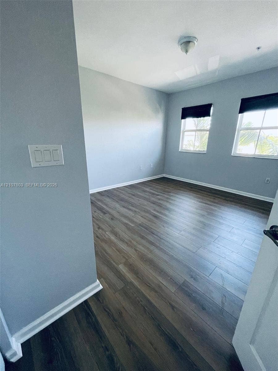 8620 NW 97th Avenue, #205, Doral, FL 33178 Room featuring wood-finish flooring, dual windows with multi-pane glazing, and neutral wall paint