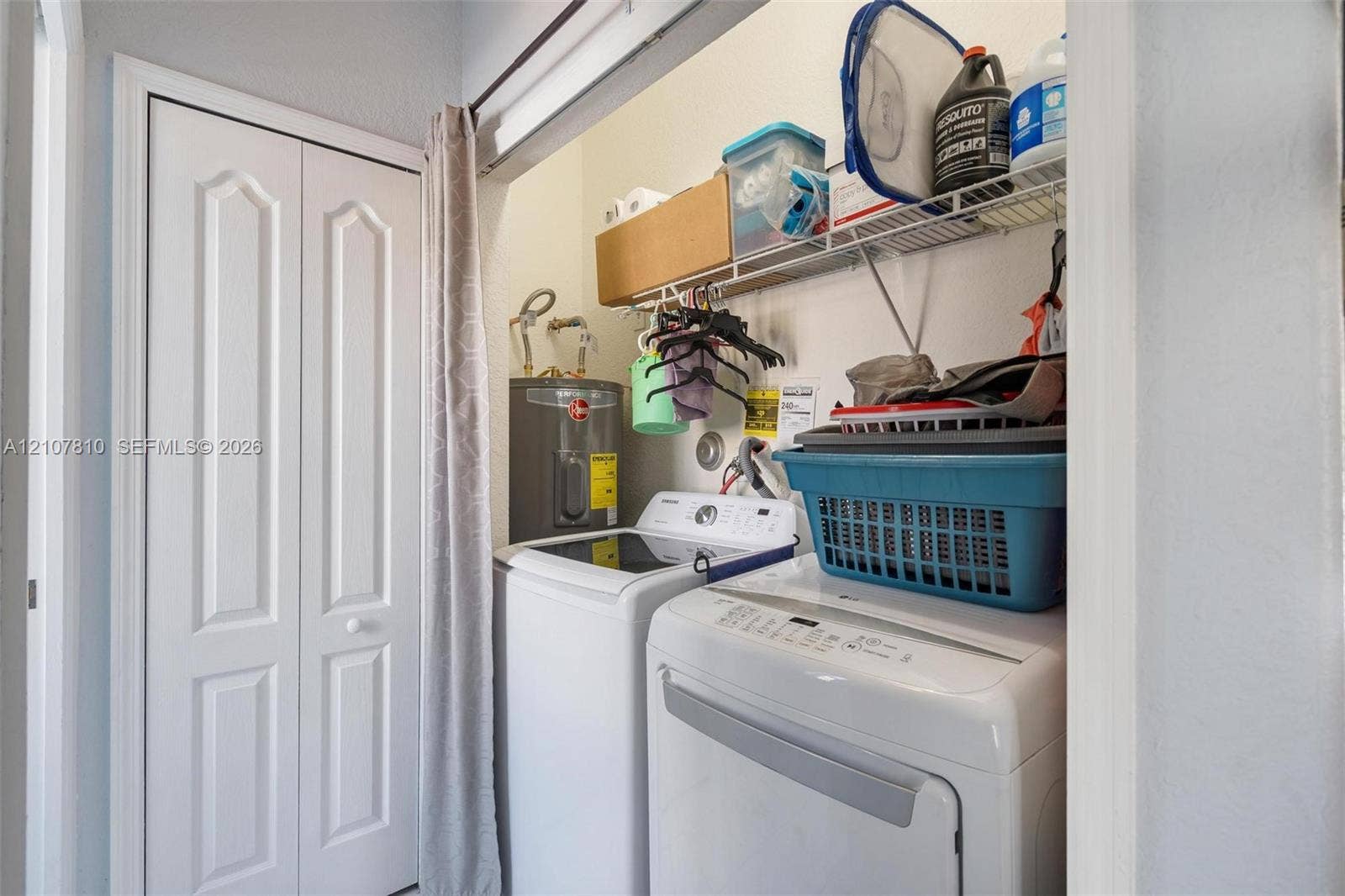 6940 NW 177th Street, #P105, Hialeah, Hialeah, FL 33015 Laundry closet featuring white bi-fold doors and integrated overhead wire shelving