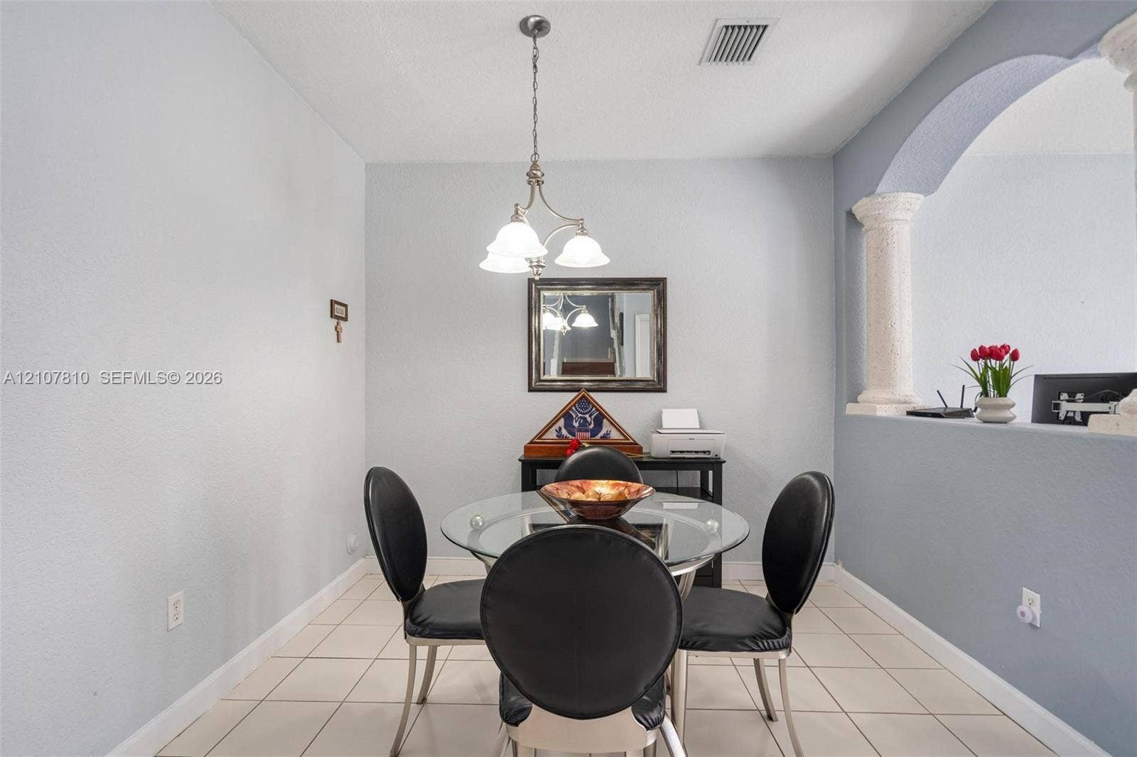 6940 NW 177th Street, #P105, Hialeah, Hialeah, FL 33015 Interior area featuring ceramic tile flooring, a multi-light pendant chandelier, an arched wall cutout, and a decorative column