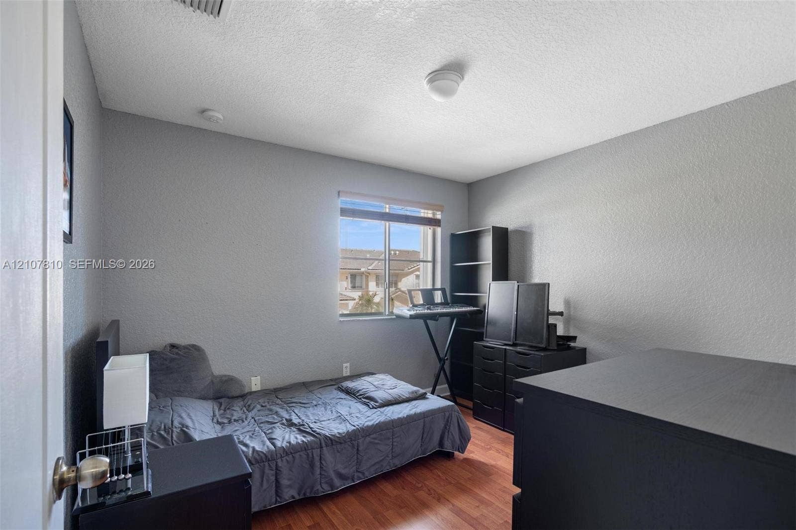 6940 NW 177th Street, #P105, Hialeah, Hialeah, FL 33015 Interior space featuring wood-finish flooring, neutral-toned walls, and a single-pane window