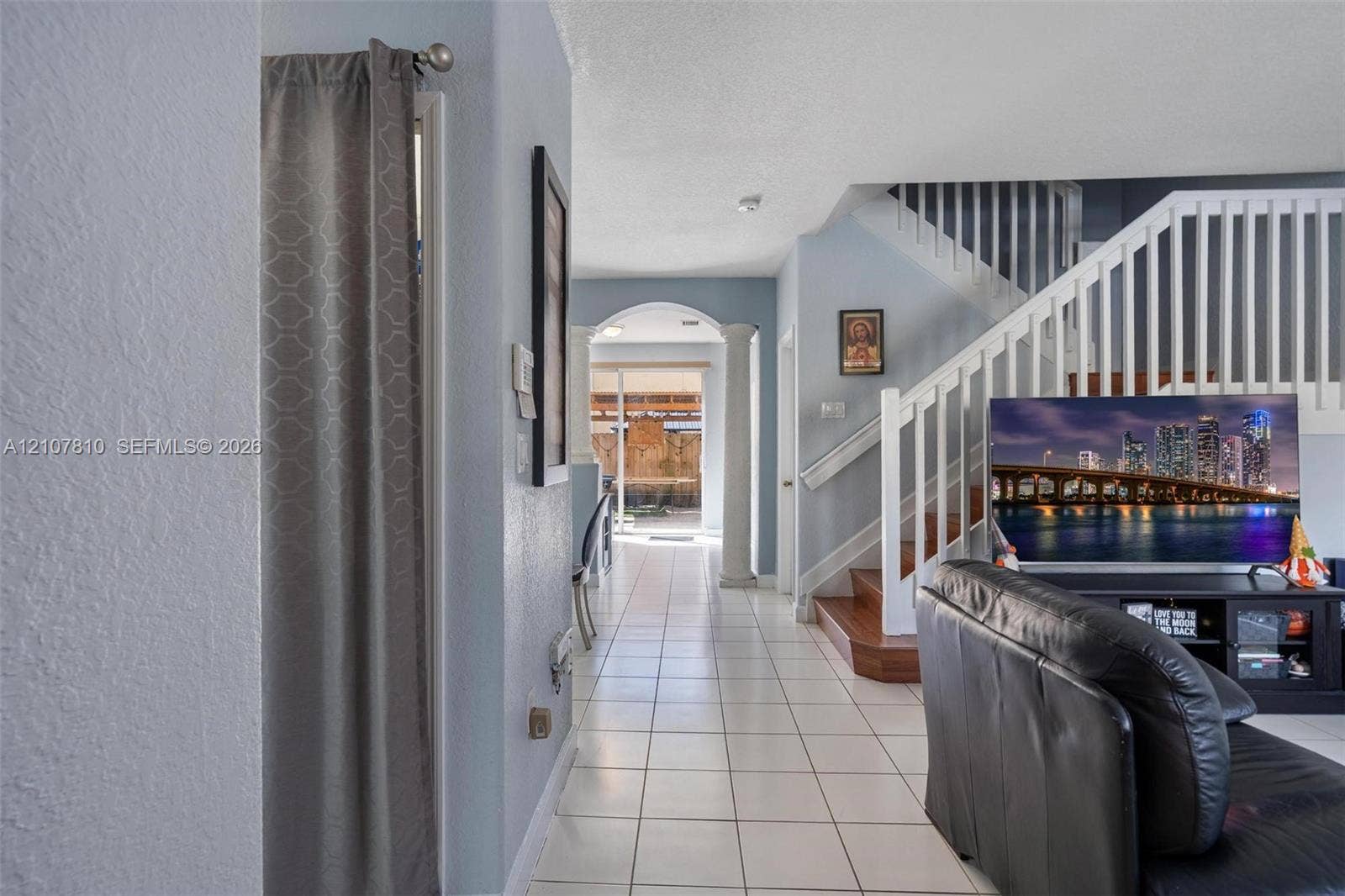 6940 NW 177th Street, #P105, Hialeah, Hialeah, FL 33015 Ceramic tile flooring, white wooden staircase railing, and architectural columns